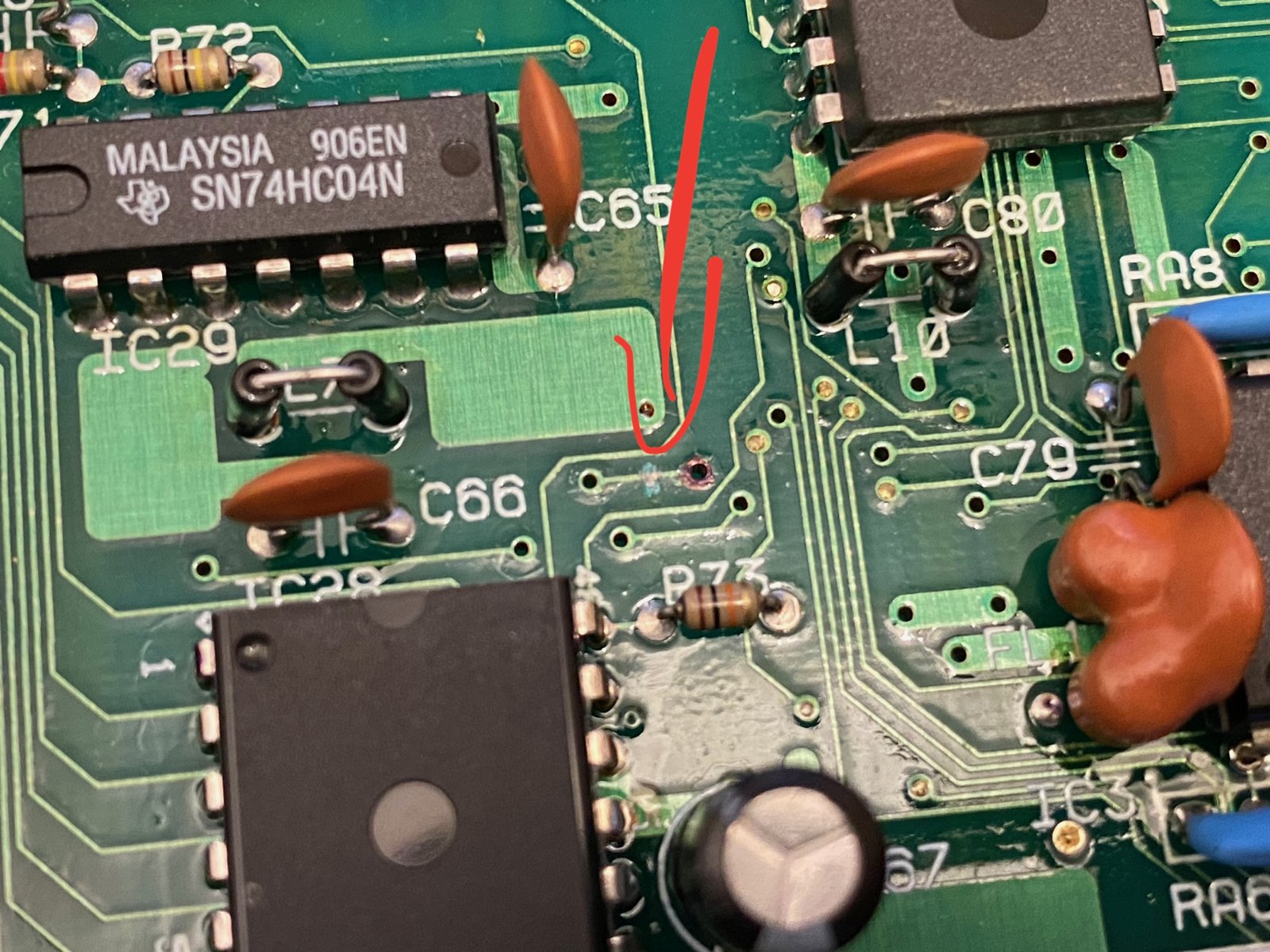 The trace to cut, marked with a red arrow, next to IC29, an SN74HC04N The trace to cut, marked with a red arrow, next to IC29, an SN74HC04N